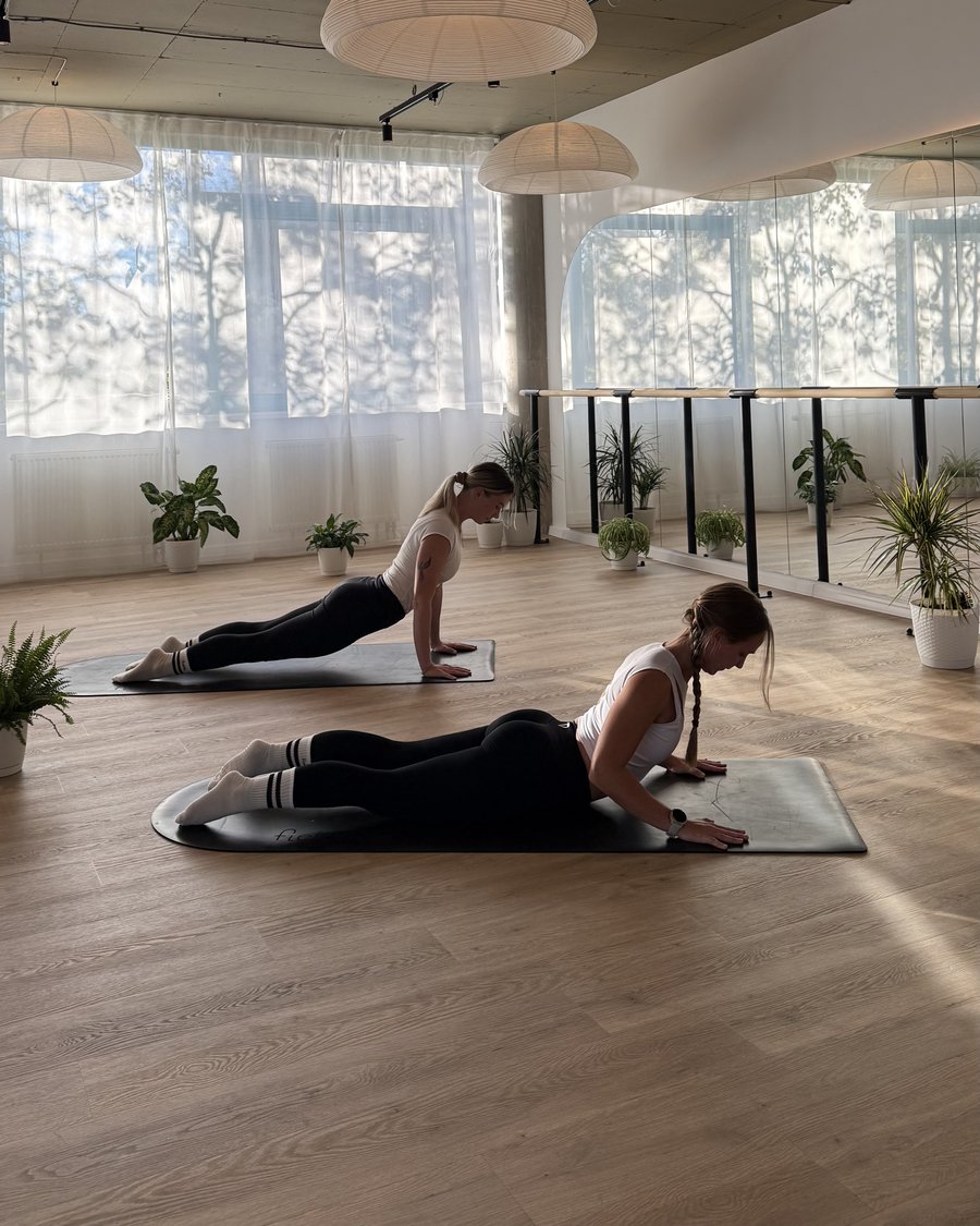 Dve ženy cvičia na podložkách v svetlej sále Flexity Pilates & Barre Poprad